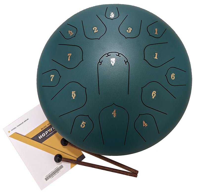 A photo of a 14 Inch steel drum with 2 wooden mallets and music book.