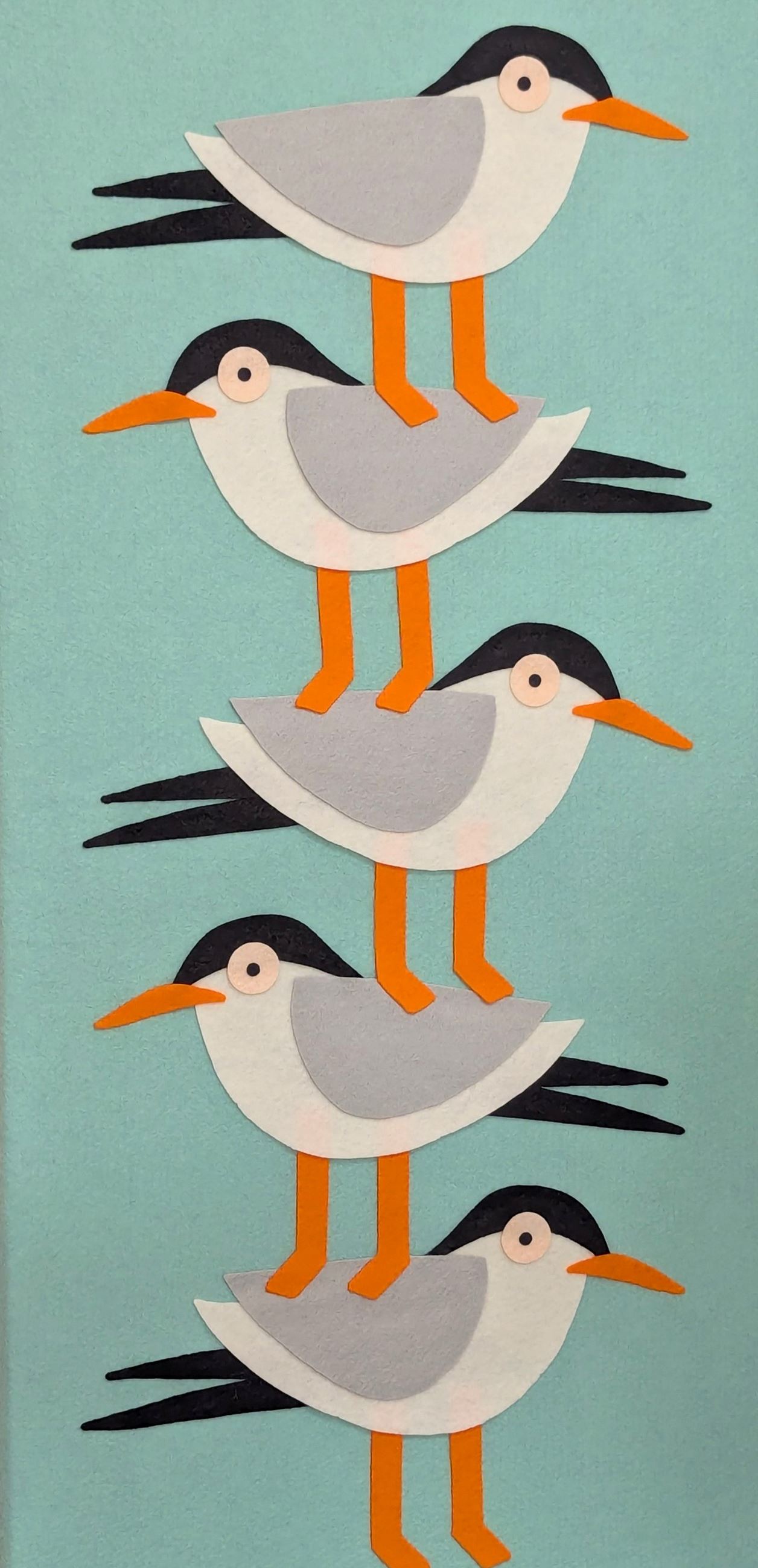 An image of 5 fabric birds standing on top of one another